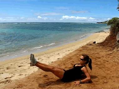 a person laying on the beach with their legs crossed