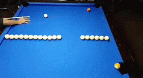 a person reaching for an eight ball on a pool table