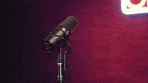 an old microphone is set against a purple wall