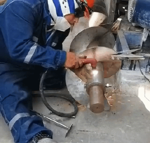 a man is welding the wheel in his workshop
