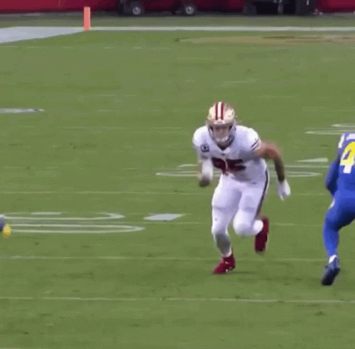 a football player runs down the field as another chases him