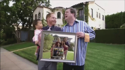 a man holds a picture of a child with her older father