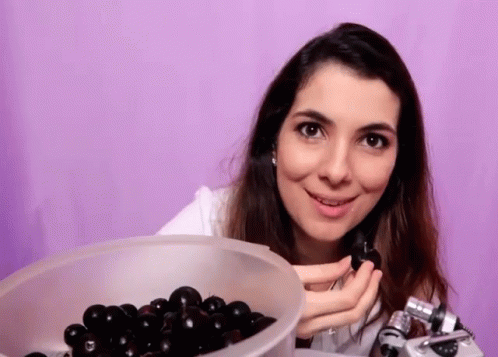 a woman holds an extra plastic bowl of olives