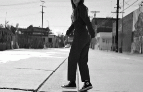 a black and white po of a woman riding on a skateboard