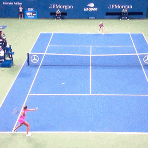 two people on a tennis court with rackets
