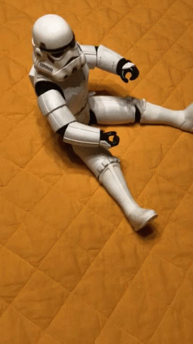 a star wars toy robot laying on a blue mattress
