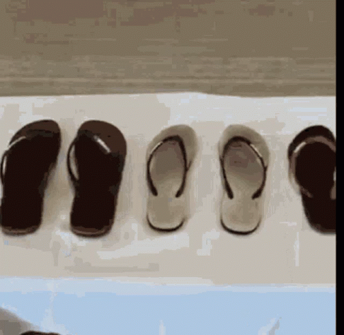 a bunch of flip flops lined up against a wall