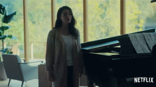 a person standing next to a piano in a living room
