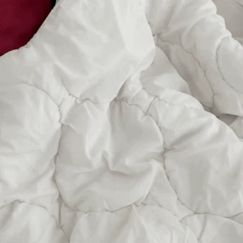 an image of a pile of white sheets with a blue pillow