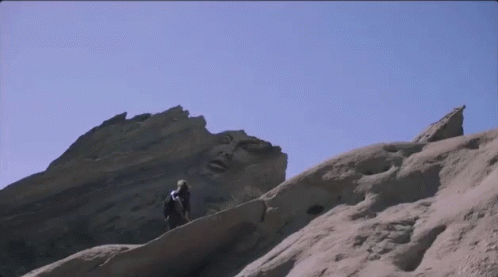 two people standing at the edge of a mountain ridge