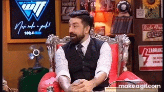 a man sits on a chair with a beard