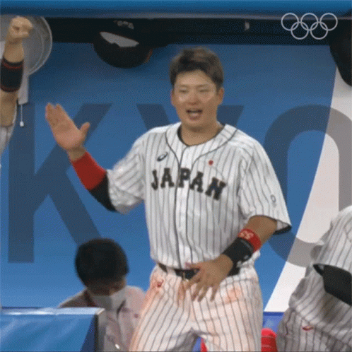 the man in the baseball uniform is making gestures with his hands