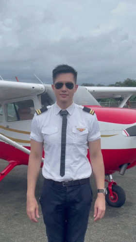 a young man standing next to an airplane