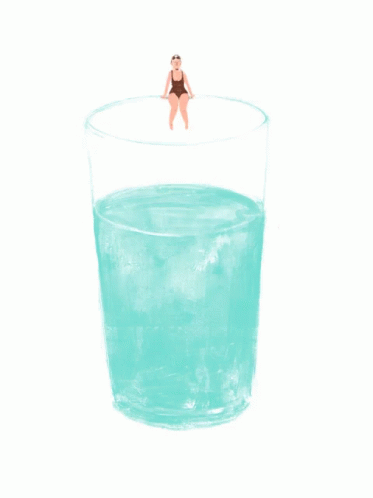 a glass with a yellow drink inside and a figure