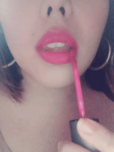 a woman holding a tooth brush to her mouth