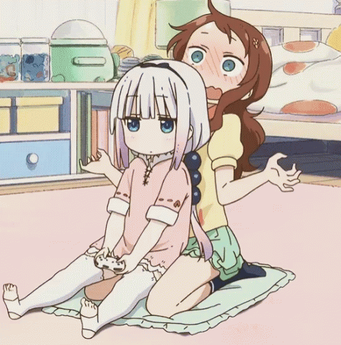 a couple of anime characters sitting on a bed