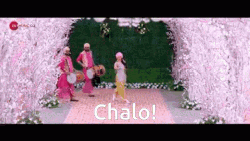 four people in purple costumes walk across a pathway that reads chalo