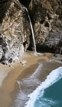 this is an image of a beach with water coming out of the rocks