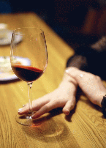 a close up view of someone holding a wine glass