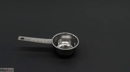 a measuring spoon with a handle sitting on a table