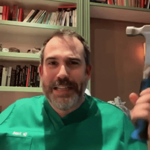 a man with blue paint on his face holds a toothbrush