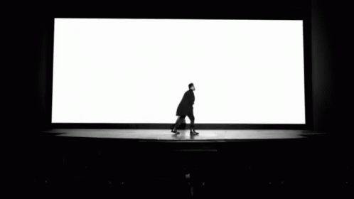 a person is walking toward a huge screen