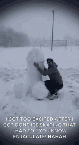 man making a snowman out of snow in front of a sign
