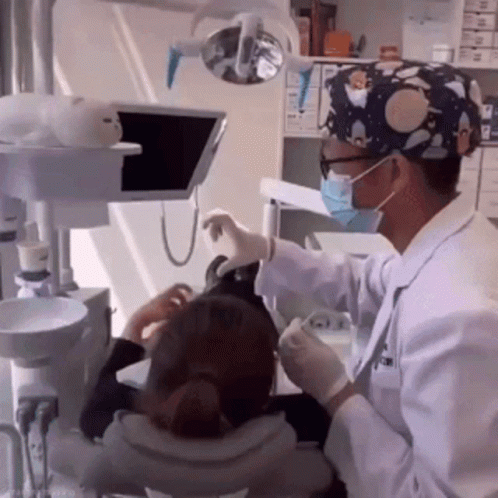 a dentist examines a womans teeth while a man watches