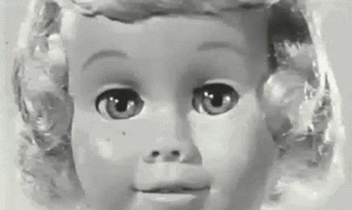 a doll with blonde hair is looking directly at the camera
