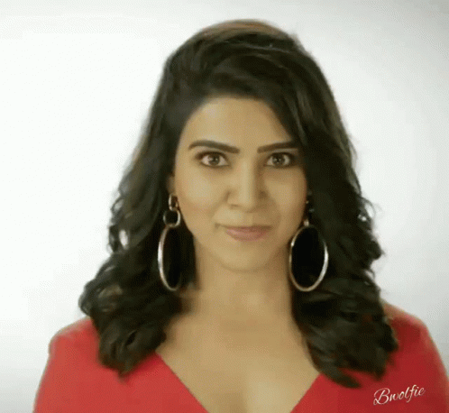 an indian woman in a blue shirt and hoop earrings