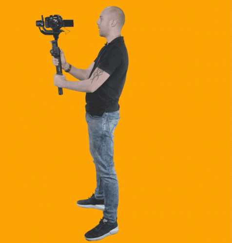 a man is standing up with a video camera