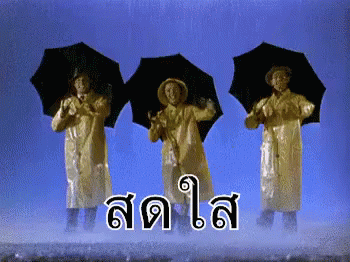 three women standing on top of a hill in the rain