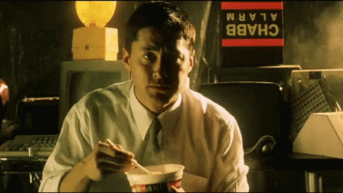 a man is eating soing in a dark office