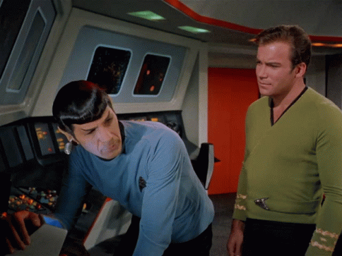 star trek crew members in green and blue clothing in a scene
