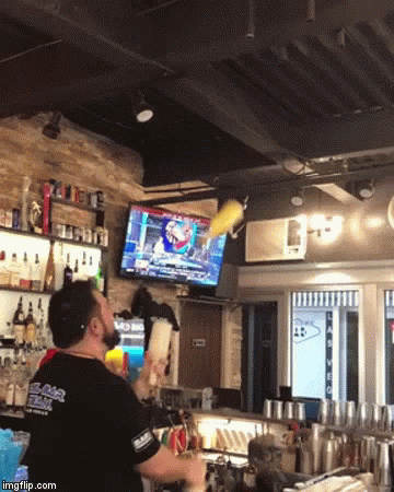 a man watching television in a bar that also sells liquor