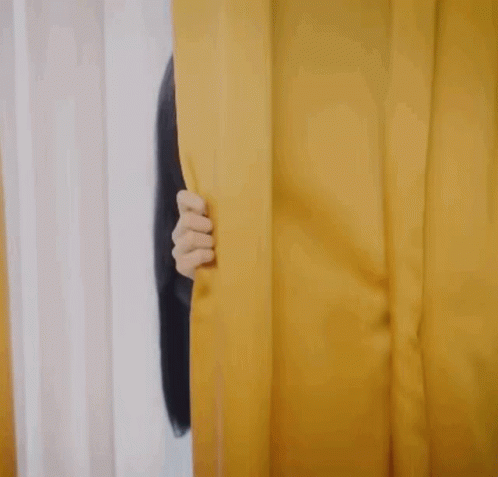 someone has their eyes shut from peeking through a curtain