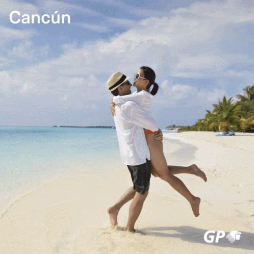 a man and woman hug in the sand of an island