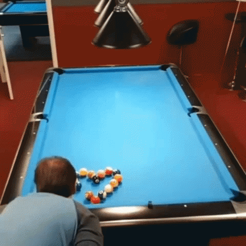 a man playing in an office with a pool table