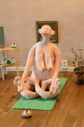 there is a statue sitting on a yoga mat