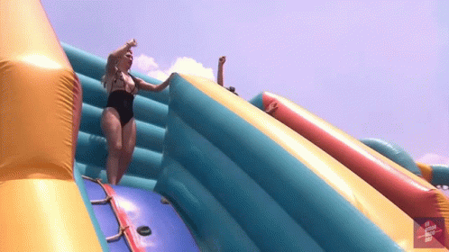 an inflatable slide with water slides and two people on it