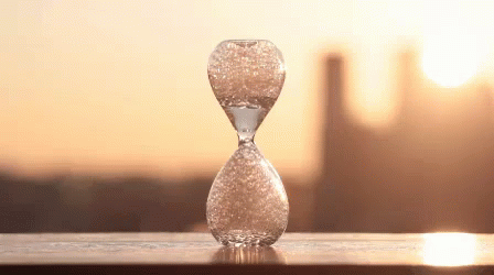 a glass vase with water inside sitting on a table