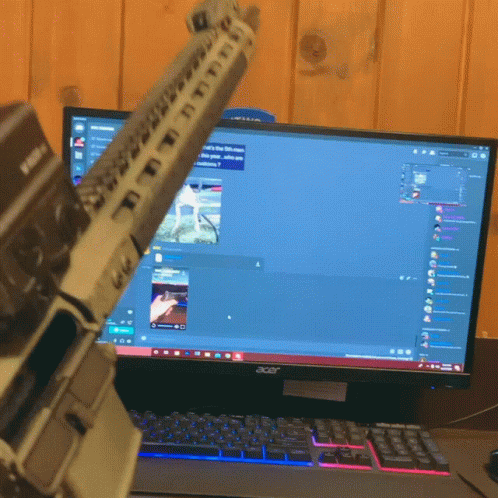 a small gray lego gun sitting in front of a computer