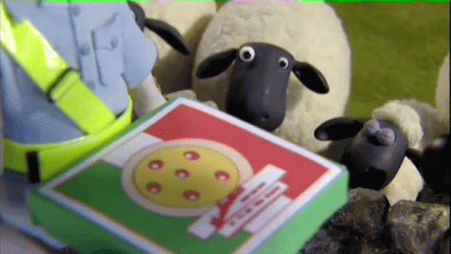 a small toy lamb and a green cardboard box