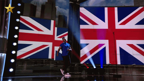 an image of a man standing in front of british flag screen