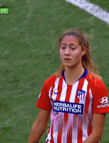 a young woman on the sidelines in a soccer game