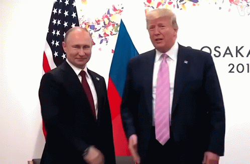 two men are shaking hands in front of flags