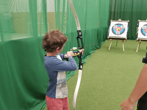 a child is holding a bow with two aiming devices
