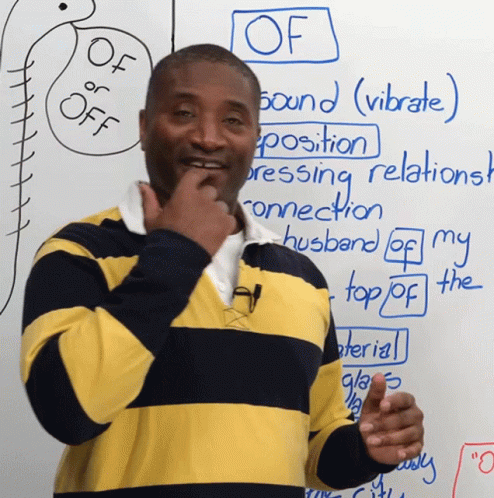 a guy holding a finger up in front of a whiteboard