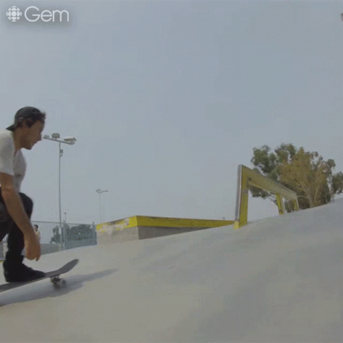 a man rides on his skateboard down a ramp