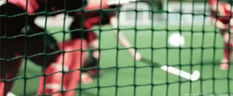 a man swings a baseball bat in the batting cage